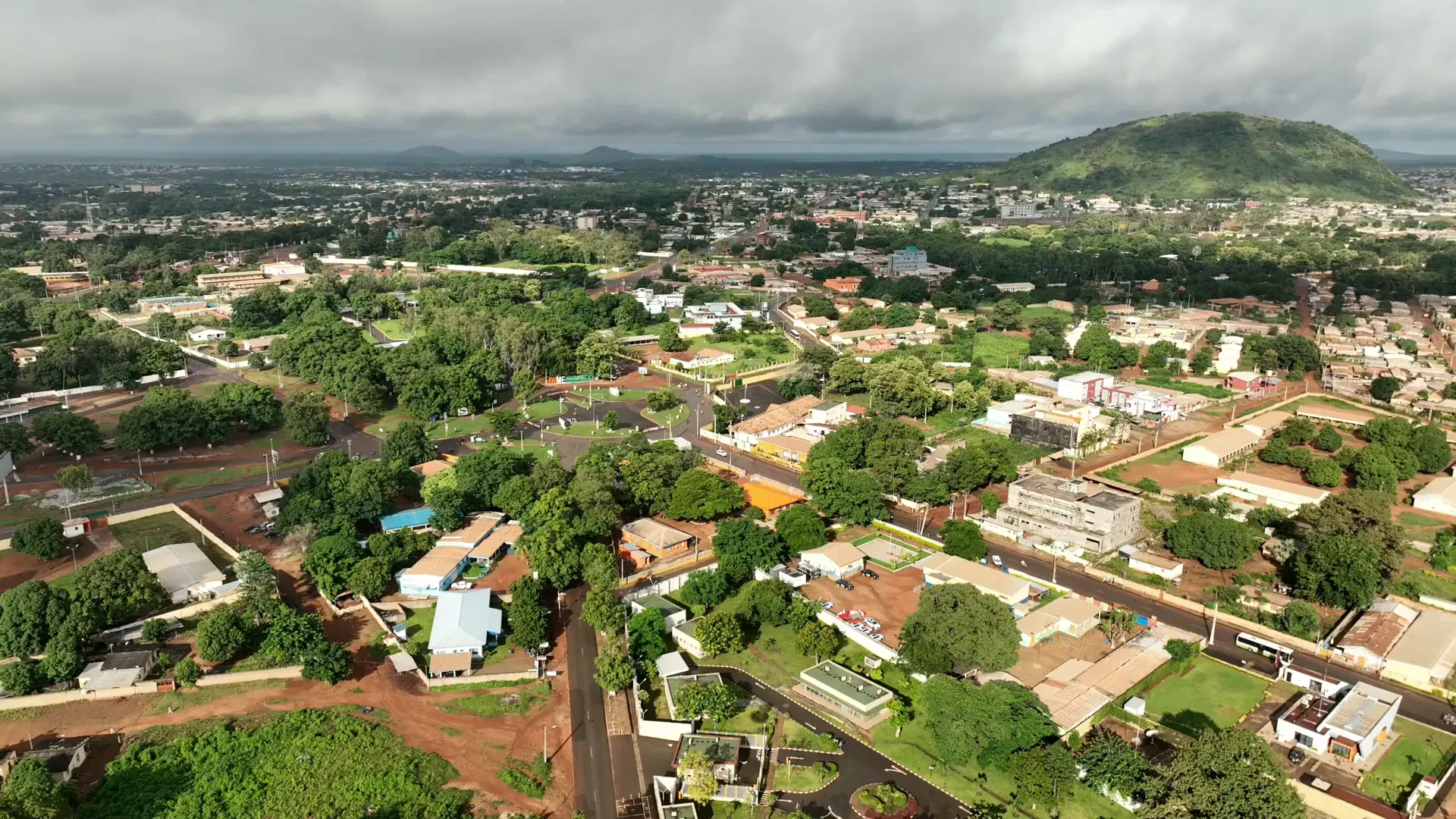 Vue aérienne d'Abidjan au petit matin, survol de la ville et de ses collines vertes.